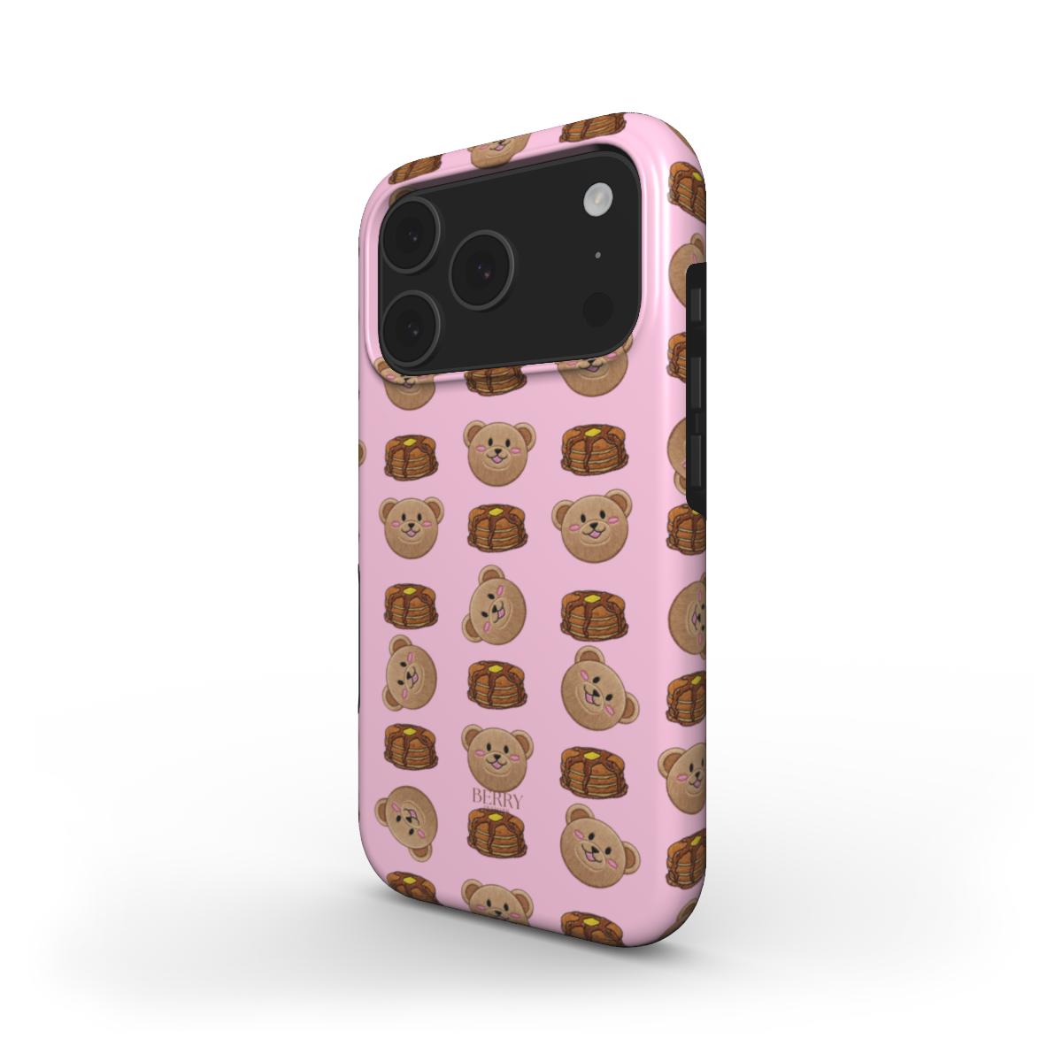 Trendy pink phone case featuring a girly pattern of cute bear faces and stacks of pancakes in beige, brown, and multicolored tones, perfect for a feminine style.